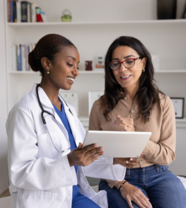 Woman reviewing healthcare information with a clinician, illustrating the connection between women’s health treatment plans and prescription access.